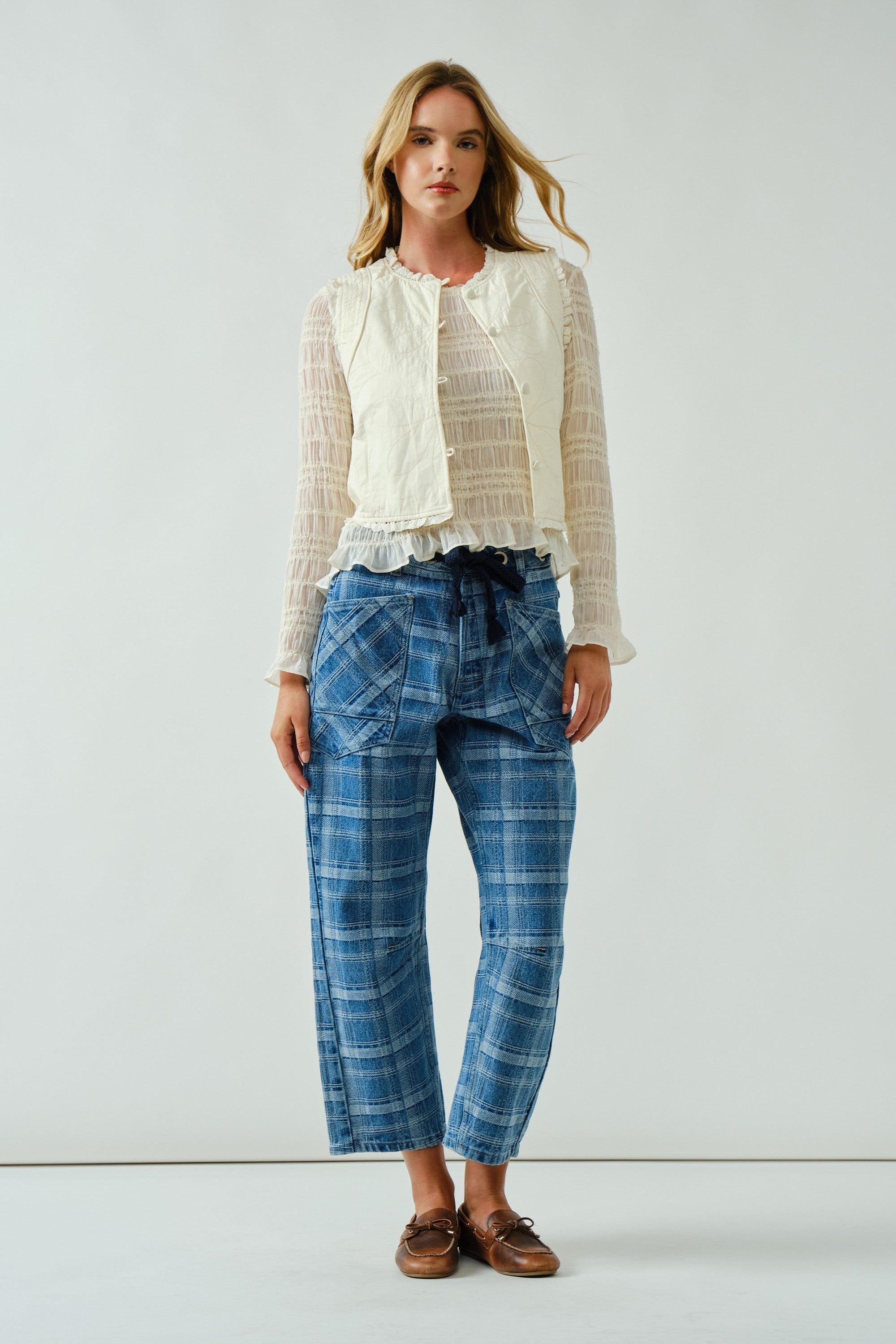 Front portrait of model wearing the Moxie Barrel Eyelet Jeans in blue plaid