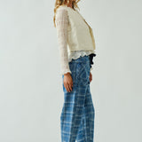 Model is wearing Moxie Jeans. Side view of the blue plaid barrel jeans highlighting relaxed silhouette