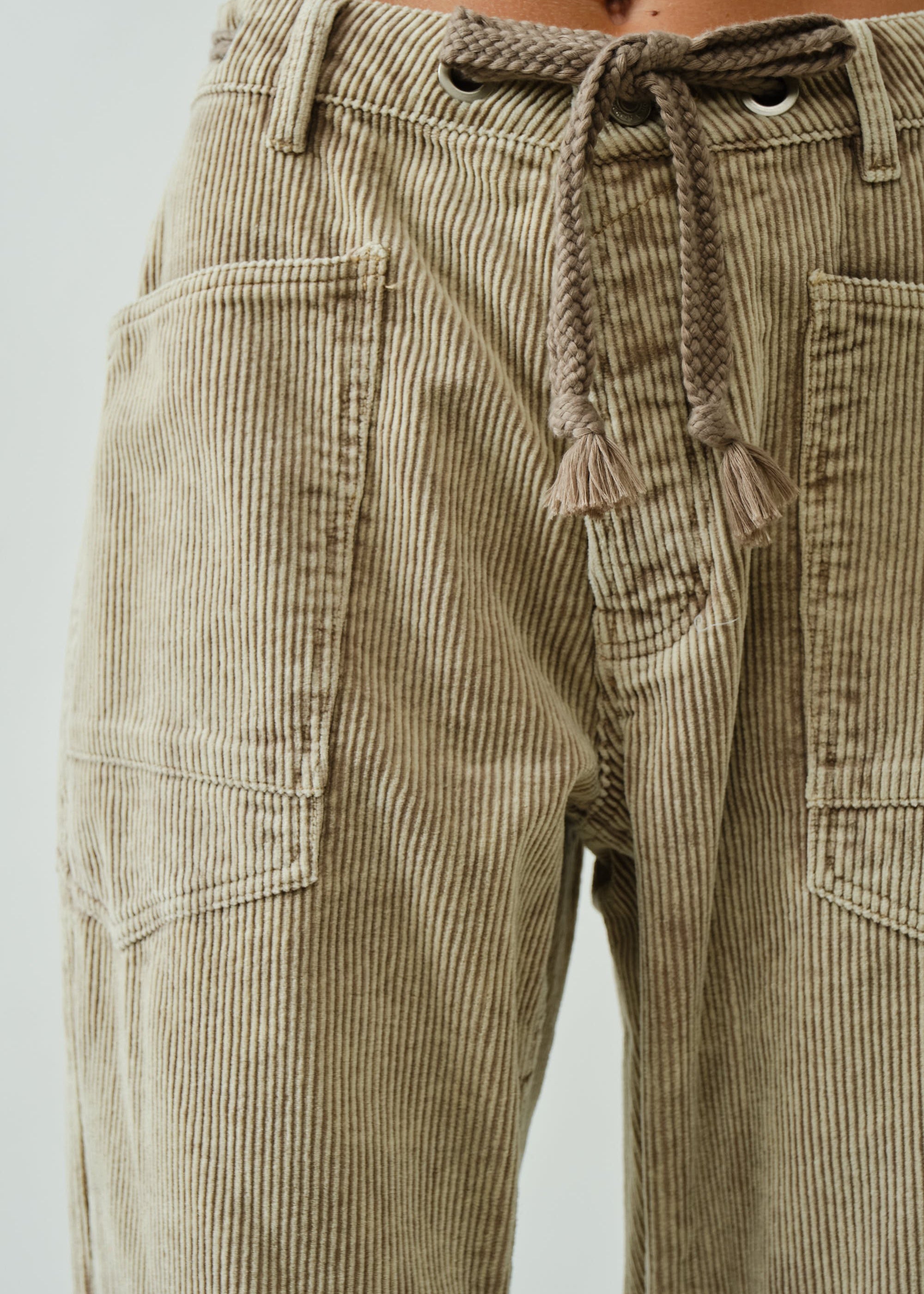 Close-up of Moxie Barrel Eyelet Jeans in corduroy dove — waist eyelet detail with corded drawstring and fine corduroy fabric.