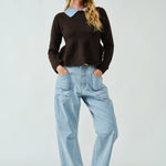 Woman wearing a dark sweater and Moxie barrel eyelet jeans in light jacquard stripe styled in a full outfit