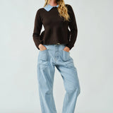 Woman wearing a dark sweater and Moxie barrel eyelet jeans in light jacquard stripe styled in a full outfit