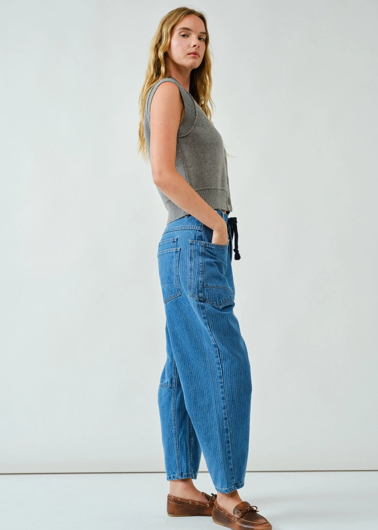 Side walking view of the barrel-leg jeans showing movement and drape