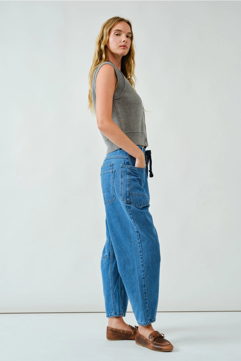 Side walking view of the barrel-leg jeans showing movement and drape