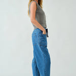 Side walking view of the barrel-leg jeans showing movement and drape