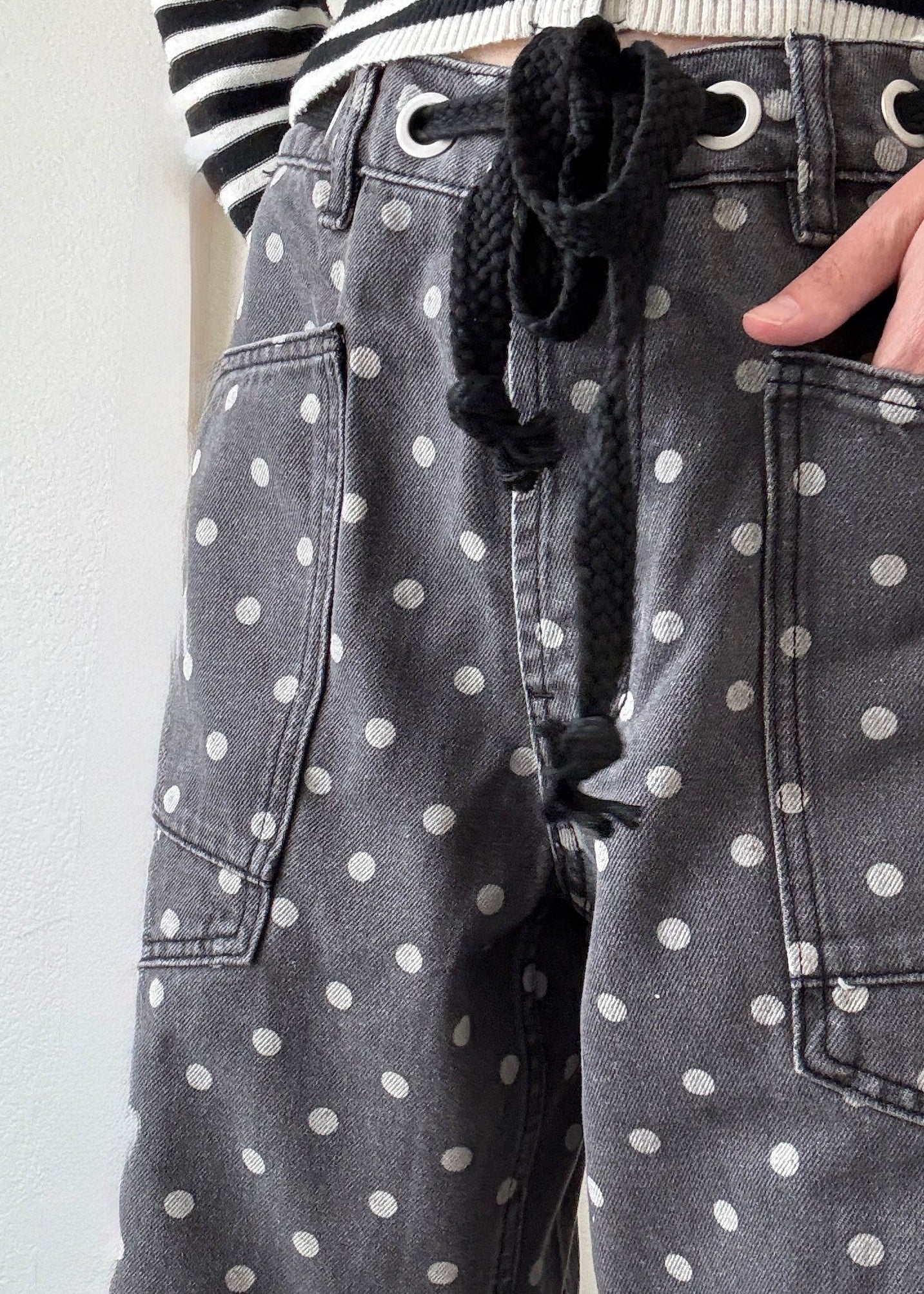 Close-up of Moxie black polka dot barrel jeans with drawstring eyelet waist and front pocket