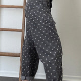 Close-up side detail of Moxie Barrel Eyelet Jeans in Polka Dot Black showing the relaxed barrel shape, pocket detail, and white dot print.