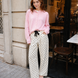 Woman wearing Moxie Barrel Eyelet Jeans in polka dot cream with a pink cardigan