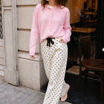 Woman wearing Moxie Barrel Eyelet Jeans in polka dot cream with a pink cardigan