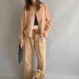 Front lifestyle view of model wearing the Moxie Barrel Eyelet Jeans in rust