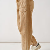 Side view of the rust barrel eyelet jeans highlighting cropped length