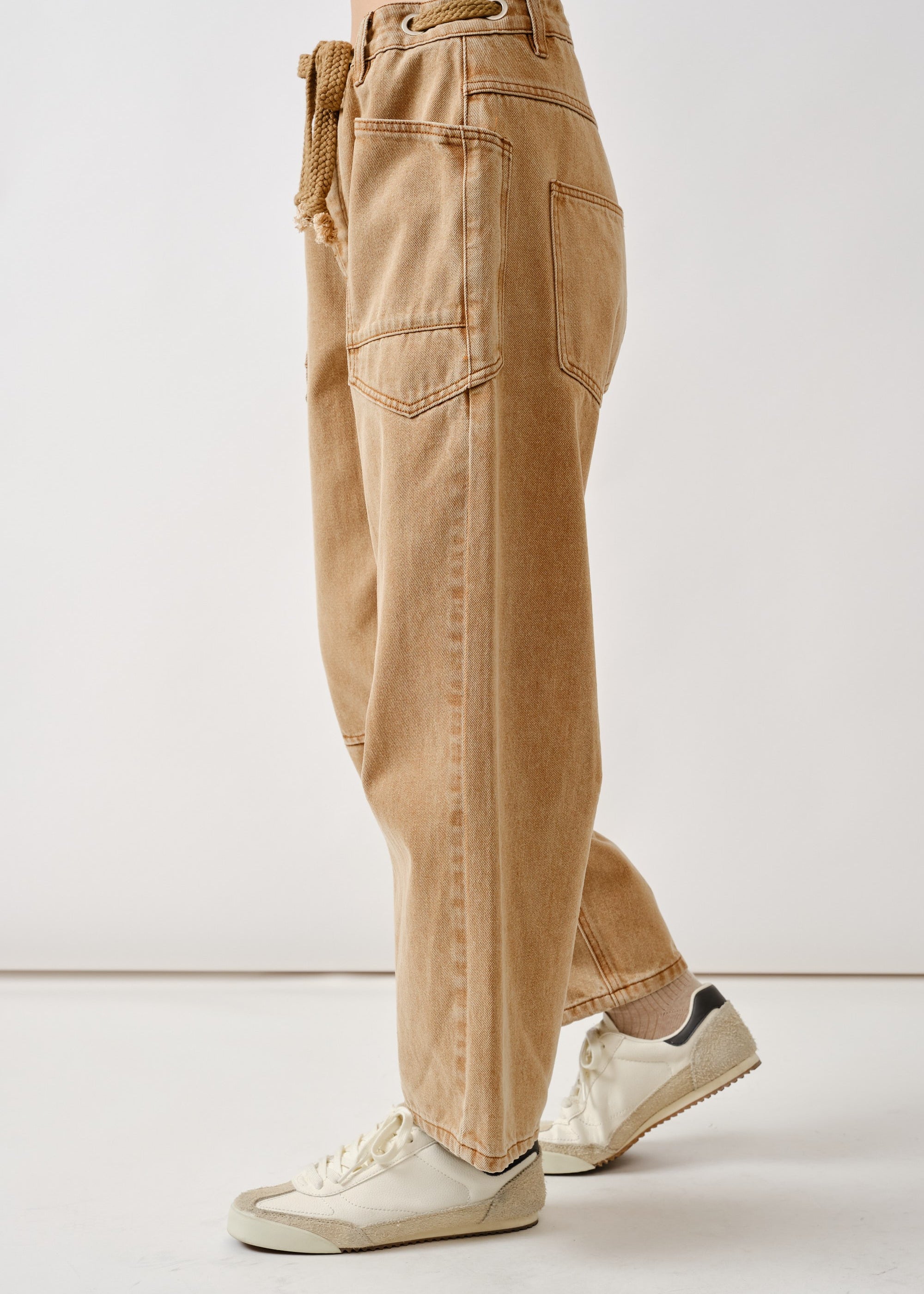 Side view of the rust barrel eyelet jeans highlighting cropped length