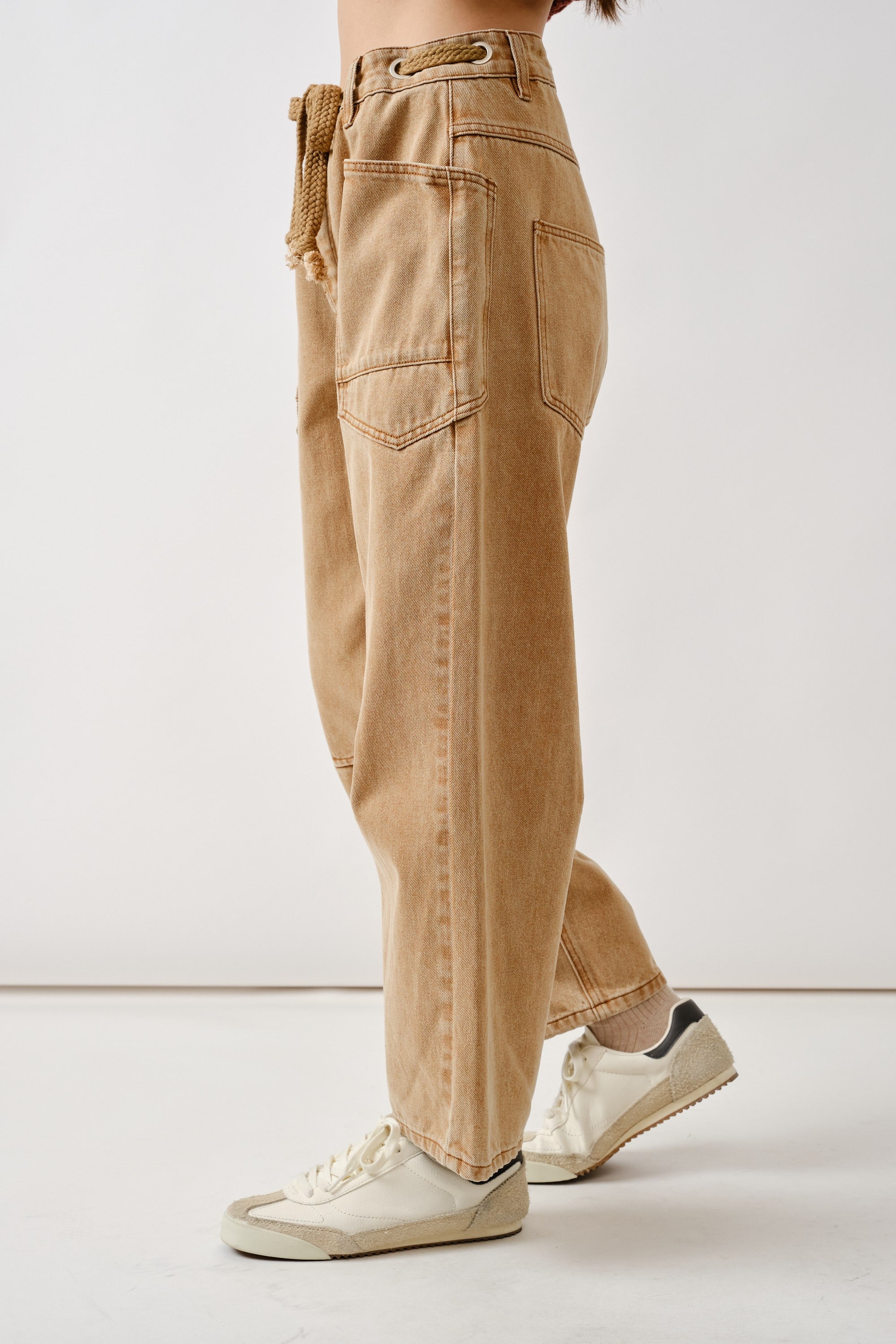 Side view of the rust barrel eyelet jeans highlighting cropped length