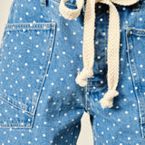 Close-up of Moxie Barrel Shorts in Denim Dot showing the drawstring waist, eyelet detail, polka dot denim, and front snap closure.