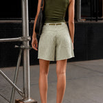 Person wearing Woman wearing Moxie Barrel Shorts in Olive Stripe styled with an easy everyday outfit standing on a city street.