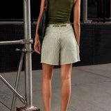 Person wearing Woman wearing Moxie Barrel Shorts in Olive Stripe styled with an easy everyday outfit standing on a city street.