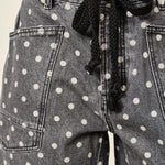 Gray denim shorts with white polka dots and a black drawstring.