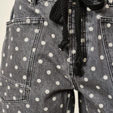 Gray denim shorts with white polka dots and a black drawstring.