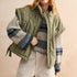 Woman wearing an olive green puffer vest with quilted texture over striped sweater and beige pants — cozy women’s outerwear for fall layering.