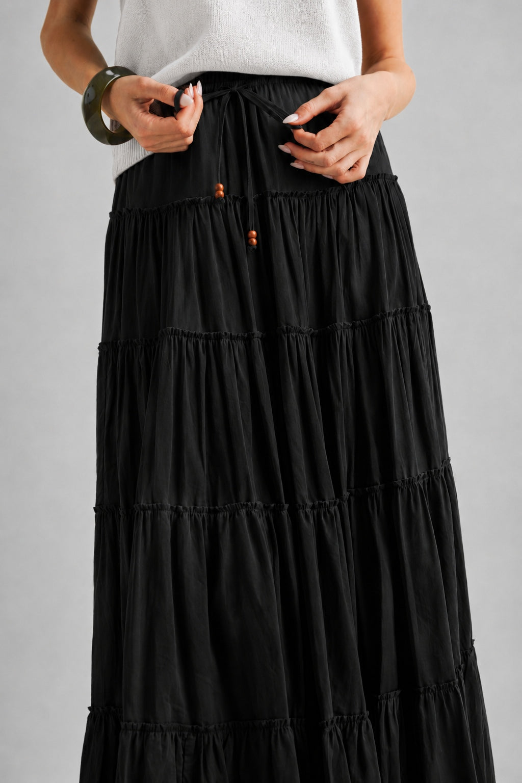 Adjustable drawstring waist on the One Brynn black cotton tiered maxi skirt