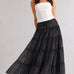 One Brynn cotton tiered maxi skirt in black styled with a white strapless top and sandals