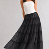 One Brynn cotton tiered maxi skirt in black styled with a white strapless top and sandals