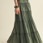 Green tiered skirt worn by a person on a beige background