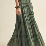 Green tiered skirt worn by a person on a beige background
