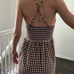 Close-up of elastic smocked back and adjustable straps on brown gingham maxi dress