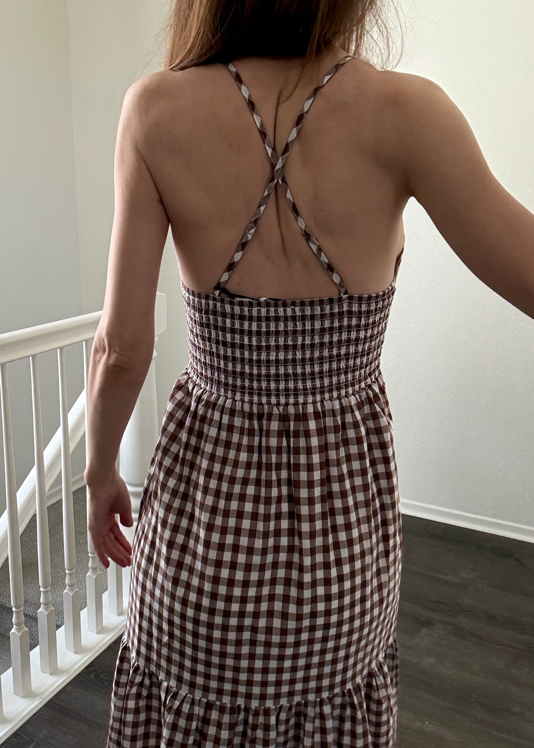 Close-up of elastic smocked back and adjustable straps on brown gingham maxi dress