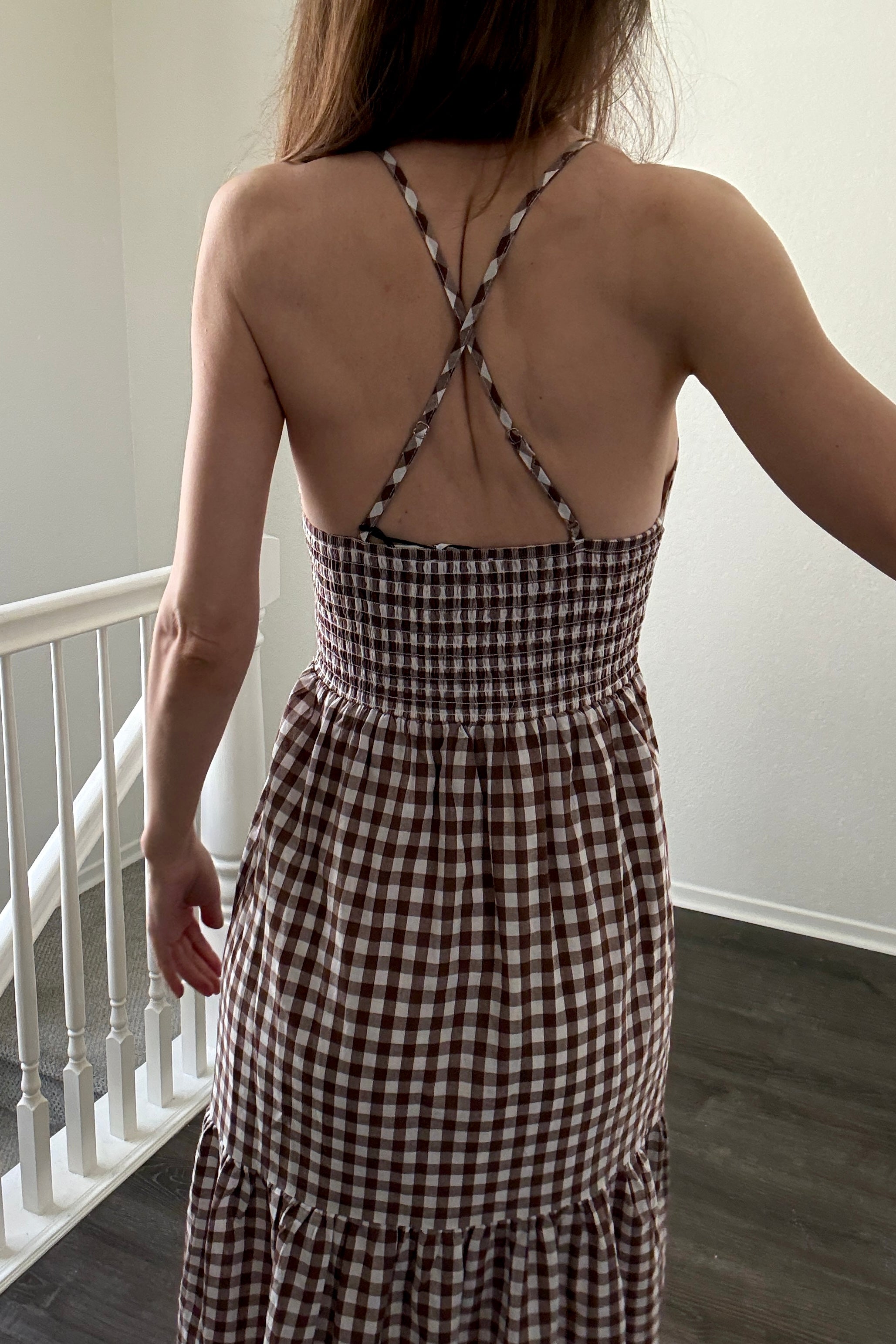 Close-up of elastic smocked back and adjustable straps on brown gingham maxi dress