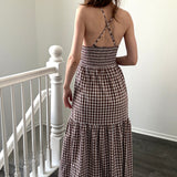 Back view of brown gingham maxi dress with smocked elastic back and crisscross straps
