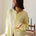 Woman wearing the Hailey Button Down Cardigan, also known as the Piper Cardigan — soft yellow lightweight knit with button front and rolled edges.