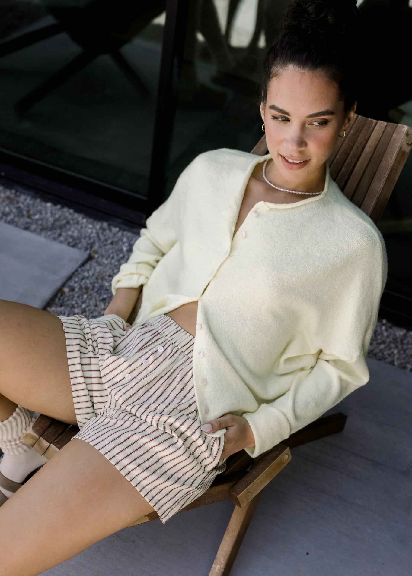 Woman sitting in a chair wearing the Piper Cardigan (Hailey Button Down Cardigan) — cozy and effortless layering piece.
