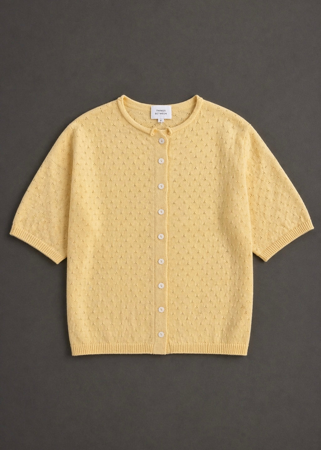 Piper Pointelle Cotton Button Down Cardigan in light yellow flat lay showing short sleeves, button front, and pointelle knit texture