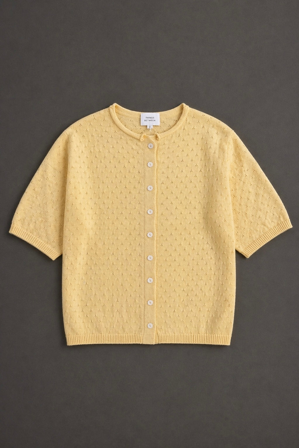 Piper Pointelle Cotton Button Down Cardigan in light yellow flat lay showing short sleeves, button front, and pointelle knit texture