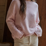 Model wearing the Piper Soft Knit Crew Sweater in Baby Pink with relaxed neutral pants - full view - side front fiew