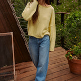 Model wearing the Piper Soft Knit Crew Sweater in Banana with relaxed neutral pants - walking