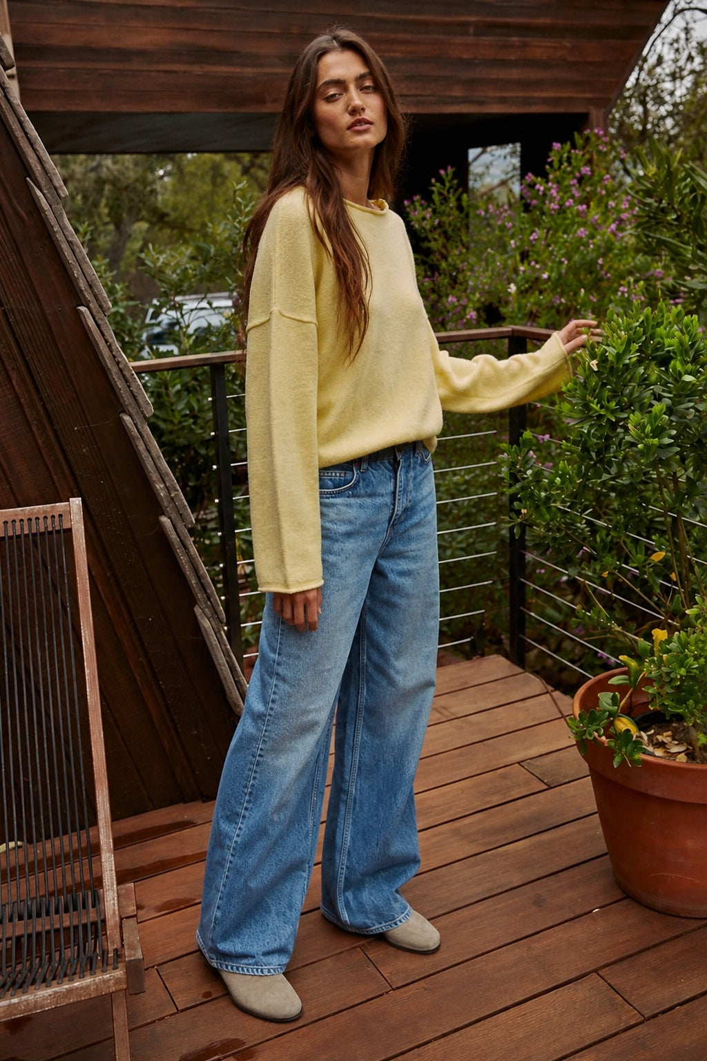 Model wearing the Piper Soft Knit Crew Sweater in Banana with relaxed neutral pants - side view
