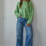 Model wearing the Piper Soft Knit Crew Sweater in Green with relaxed neutral pants - full outfit