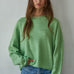 Model wearing the Piper Soft Knit Crew Sweater in Green with relaxed neutral pants - front view- main image