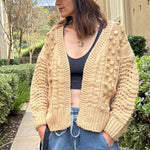 Front portrait of model wearing the Popcorn Stitch Chunky Knit Cardigan in camel