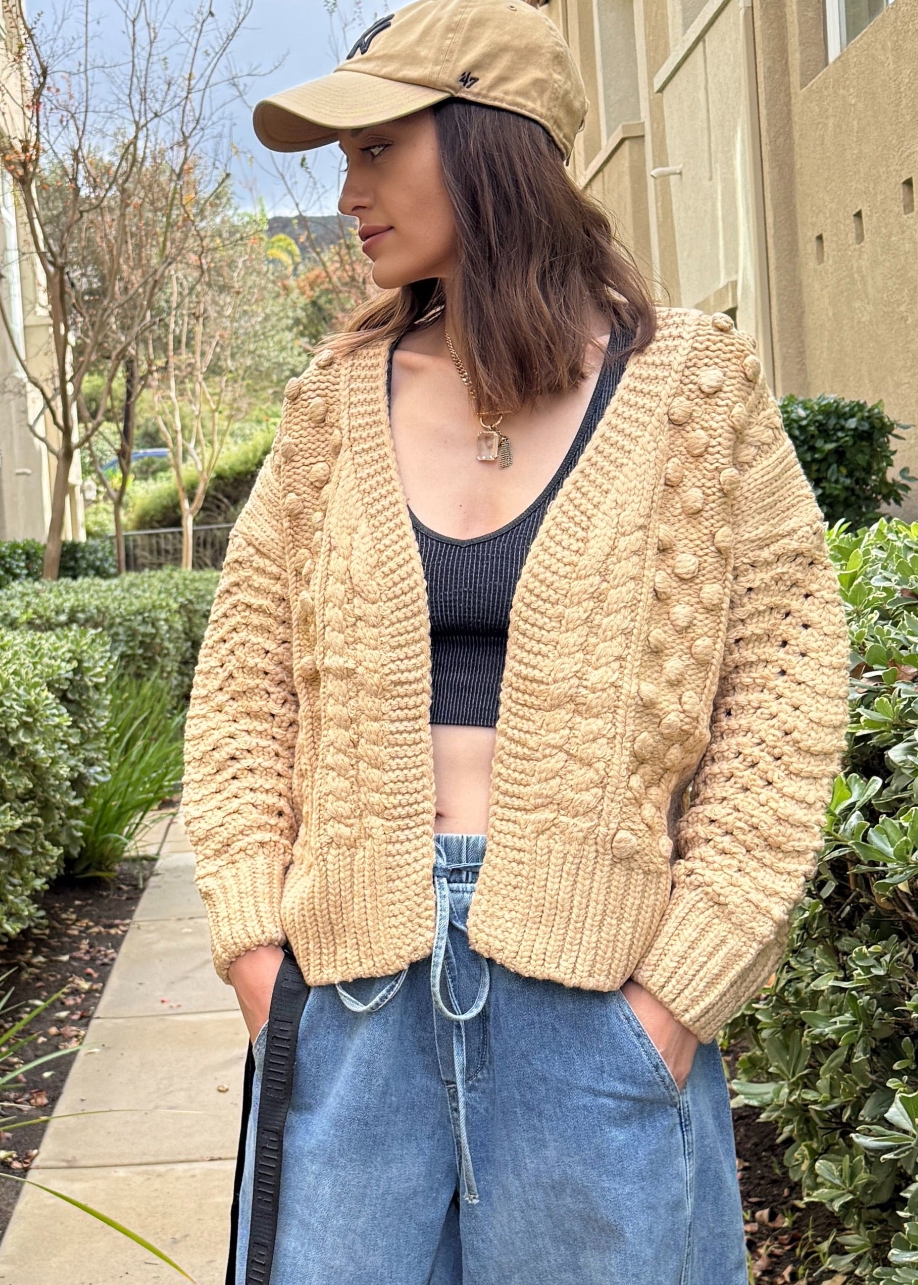 Front portrait of model wearing the Popcorn Stitch Chunky Knit Cardigan in camel