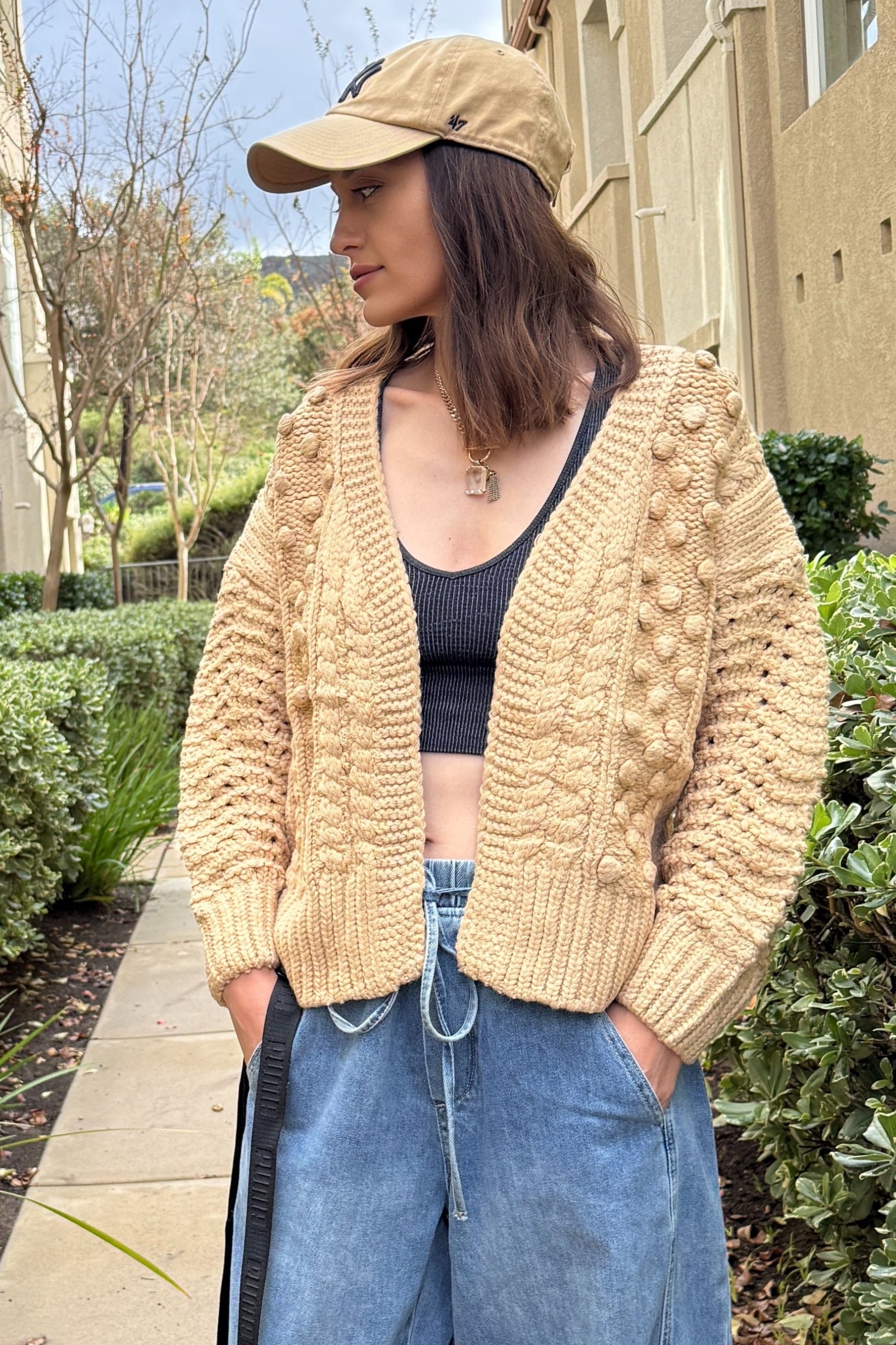 Front portrait of model wearing the Popcorn Stitch Chunky Knit Cardigan in camel