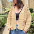 Front portrait of model wearing the Popcorn Stitch Chunky Knit Cardigan in camel