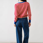 Person wearing a red and white striped sweater and blue jeans on a white background