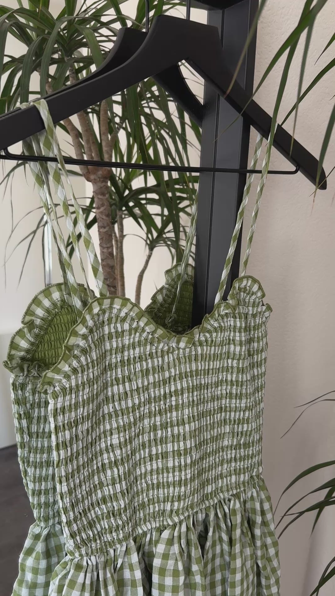Detail video showing smocked top and gingham cotton texture on green maxi dress