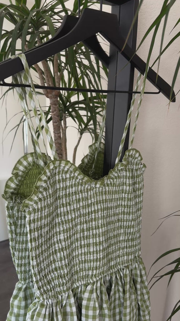 Detail video showing smocked top and gingham cotton texture on green maxi dress