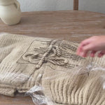 Unpackaging  the Willow Boho Tie Cardigan, also known as the Sadie Tie Front Cardigan, in red — cozy bohemian knit with tie-front closure and relaxed oversized fit.