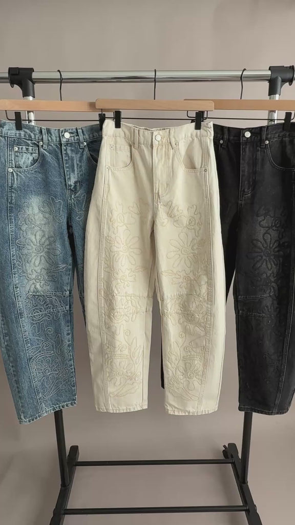 Hanging display video showing three colorways of the floral embroidered barrel-leg jeans, highlighting wash variations and embroidery details