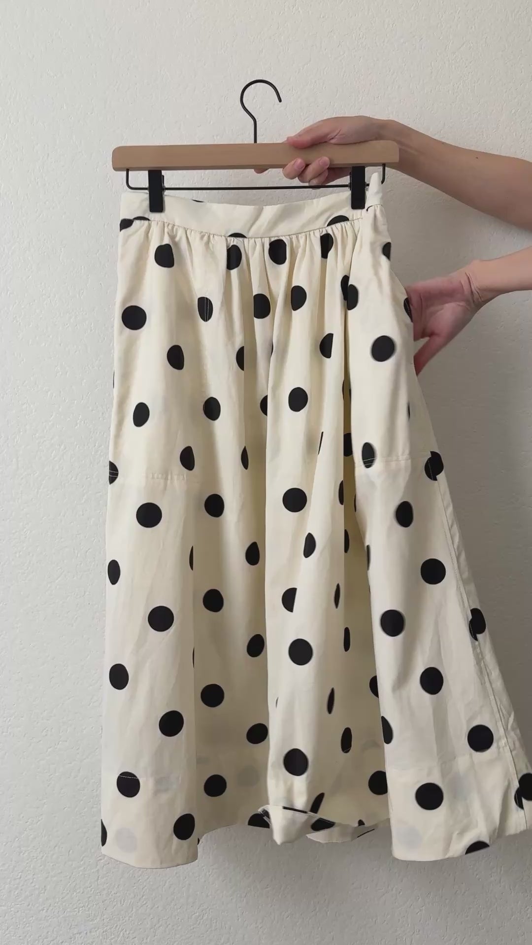 Close-up video of the Lowen Full Midi Skirt in Polka Dot Cream showing the black polka dot print, gathered waist, soft cotton-lyocell fabric, side pockets, and full midi silhouette